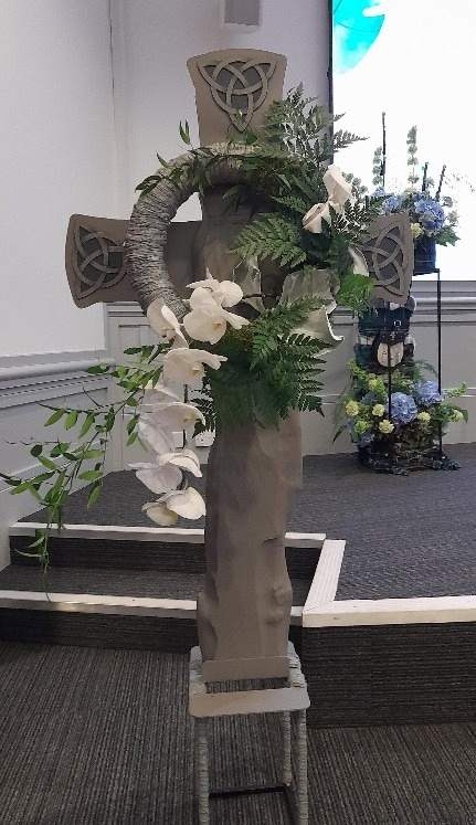 A statue with flowers on it Description automatically generated